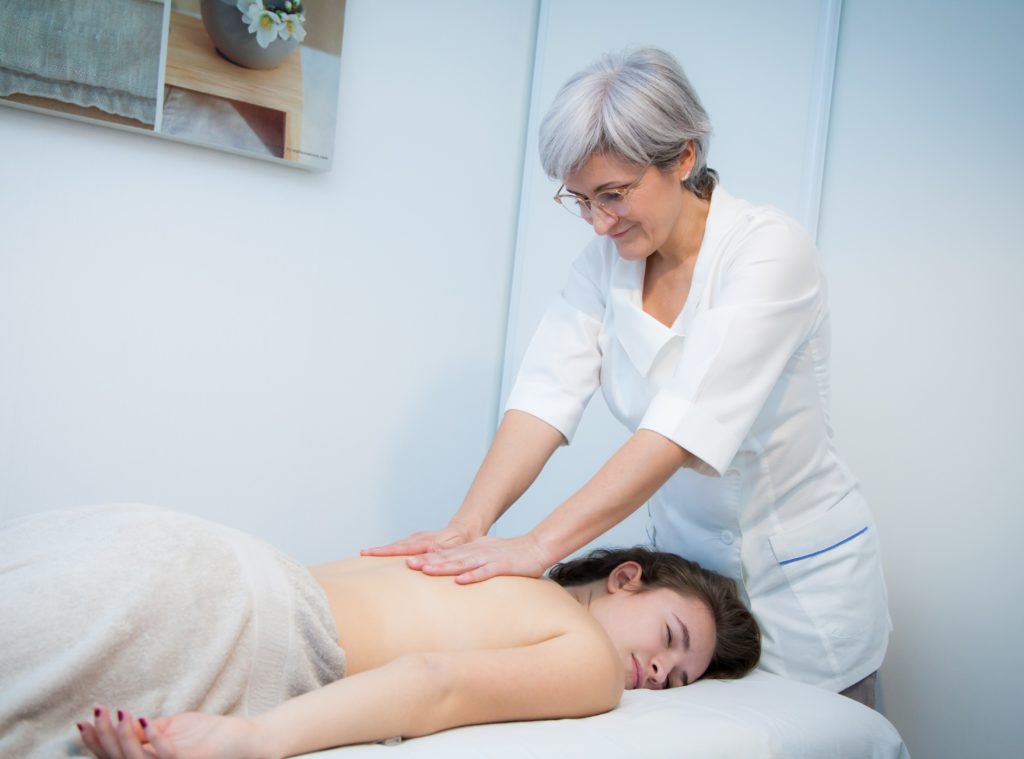 Dana au travail dans son cabinet, massage du dos sur table